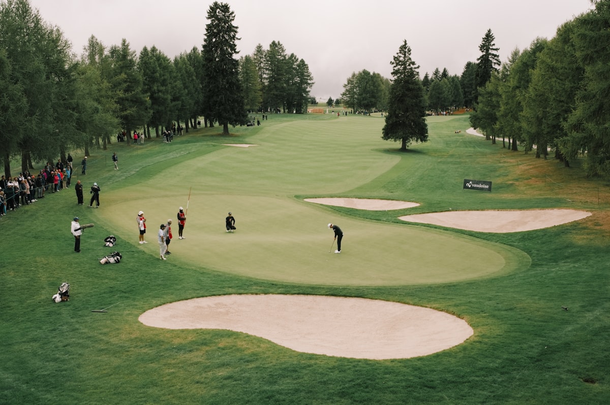 Aerial view of a professional golf tournament green with spectators and sand bunkers